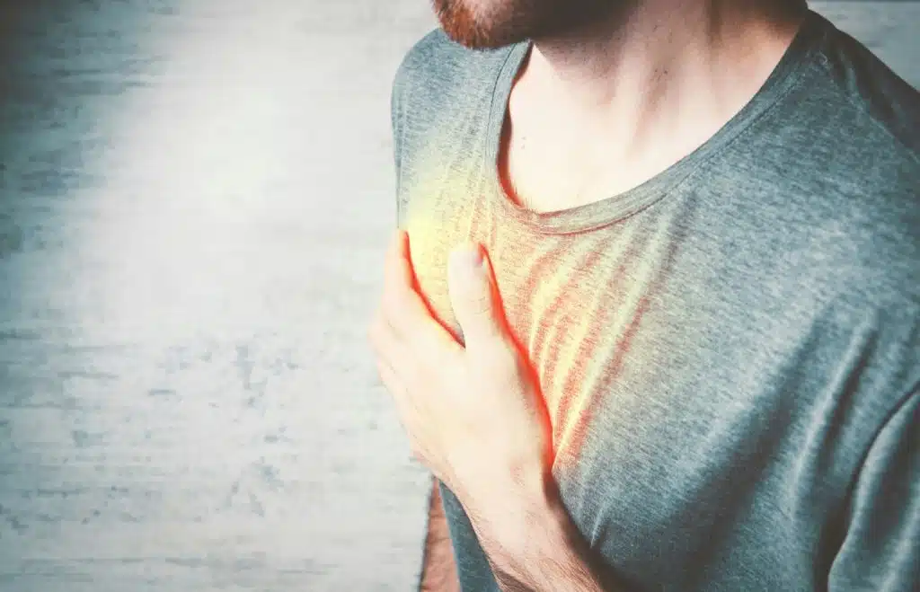 A man holding his chest and a rent tint to represent pain.