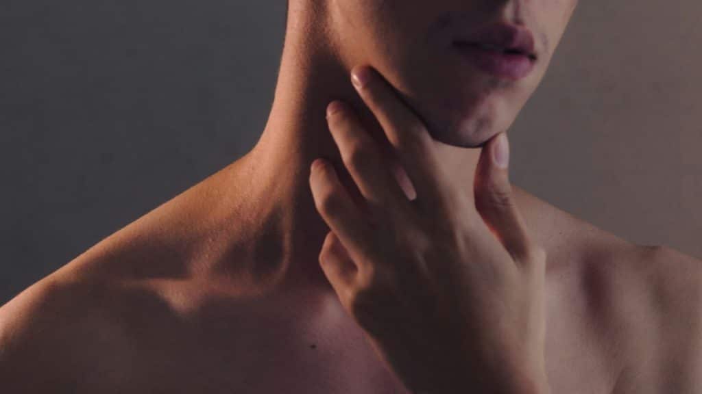A man holding his throat.