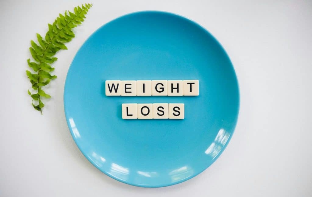 A plate with a scrabble letters that says “weight loss”.