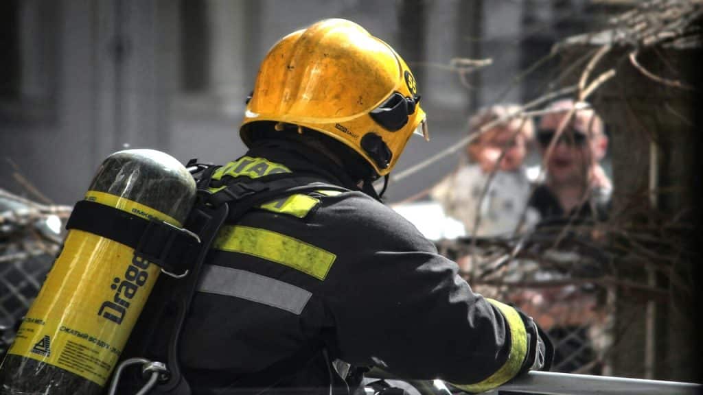 A fireman talking to people in the neighborhood.