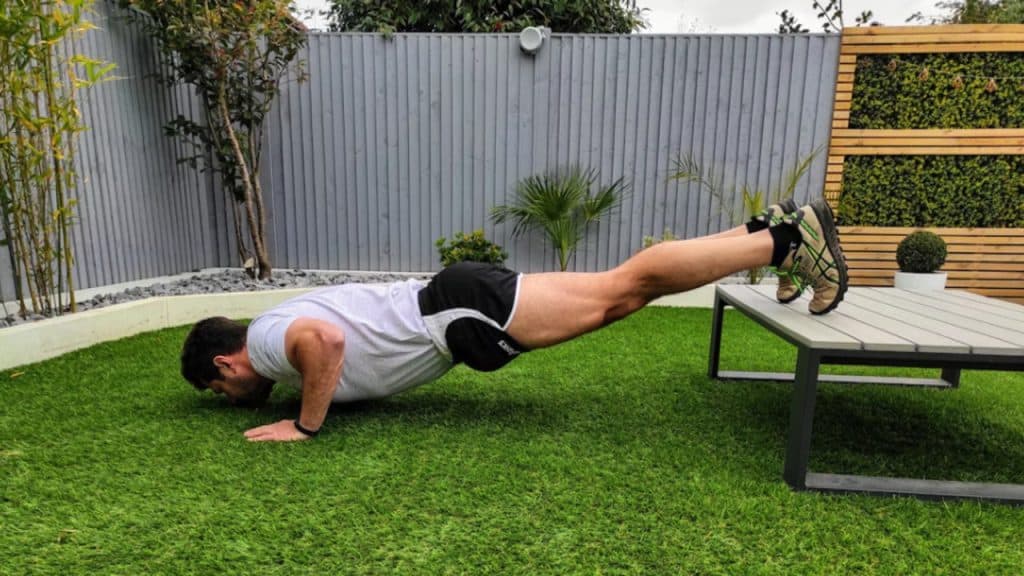A man doing a diamond push-up at home.