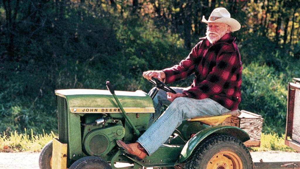 An old man driving a tractor.