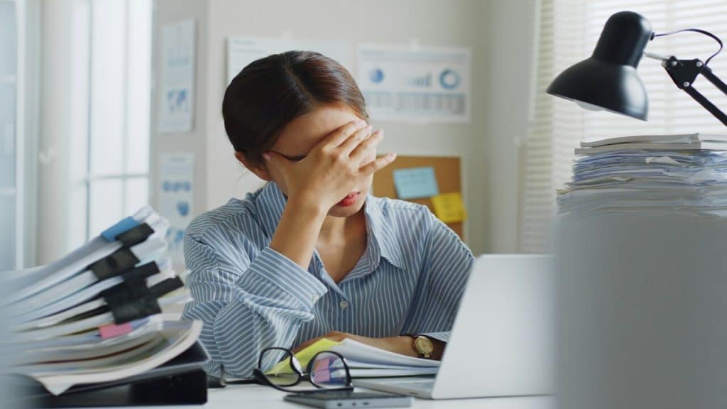 A woman looking tired and stressed at work