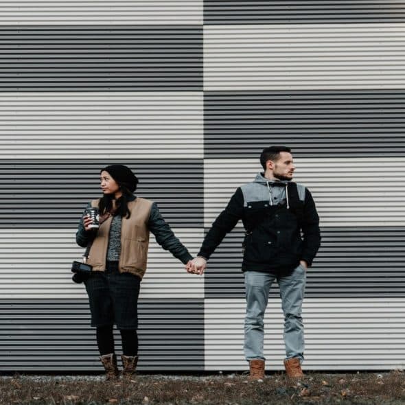 Couple holding each other’s hands but not looking at each other