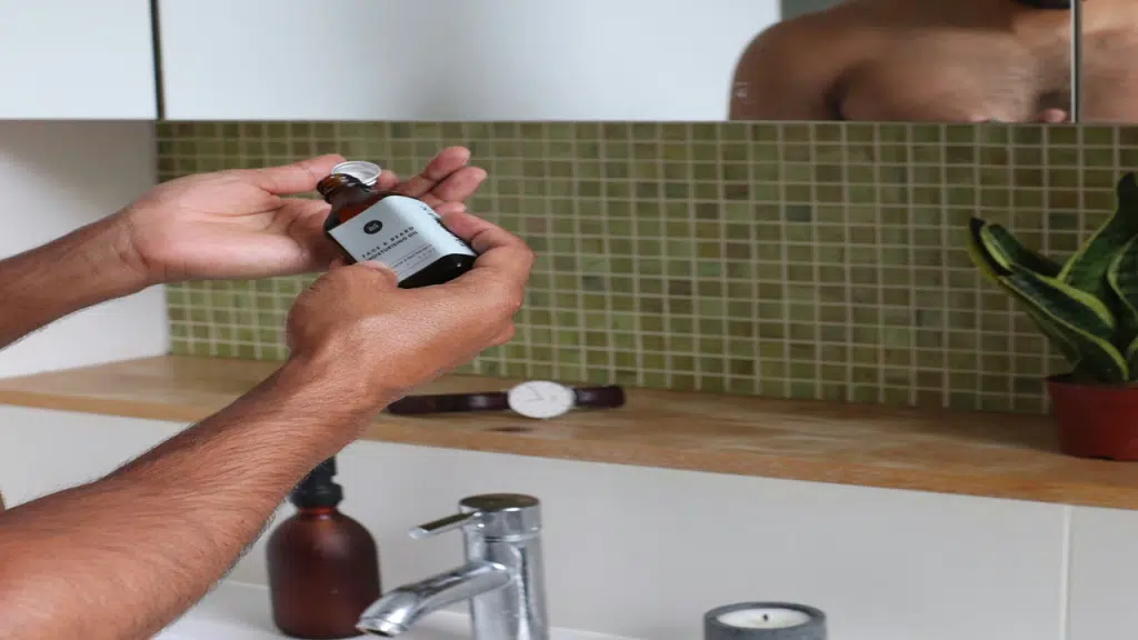 A man pours facial product onto his hand.