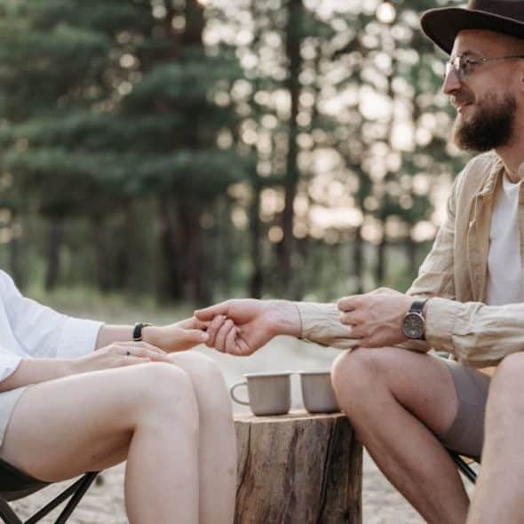 Man and woman sitting calmly across from each other in a quiet park, mid conversation.