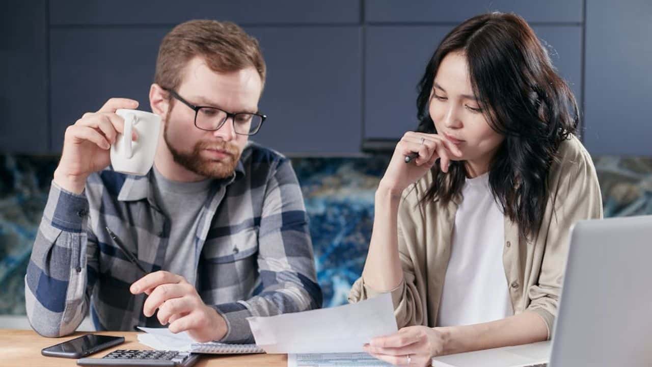 Couple sitting with a notebook or phone, setting mutual boundaries.