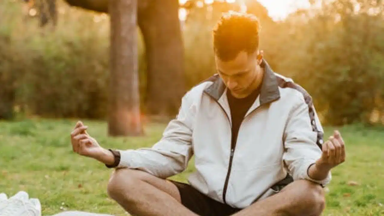 Man meditating alone in a peaceful setting.