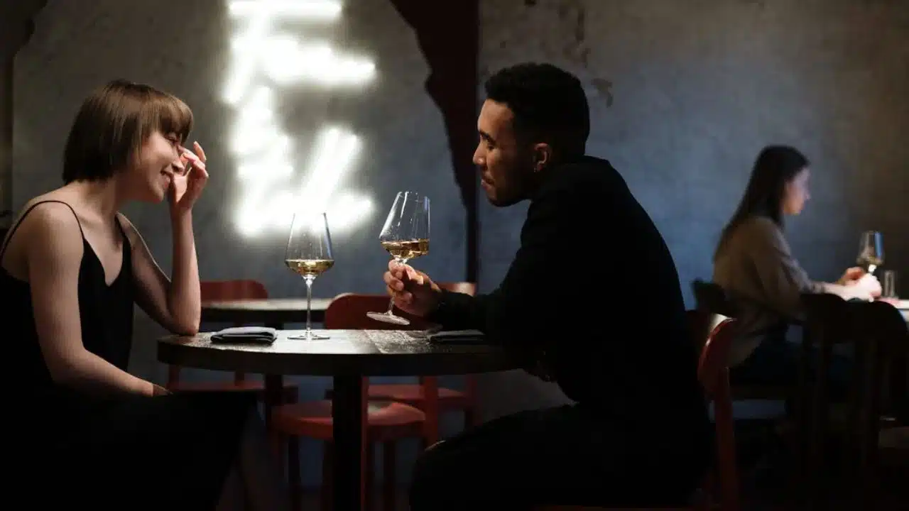 Couple sitting at a cafe table, talking seriously but calmly.