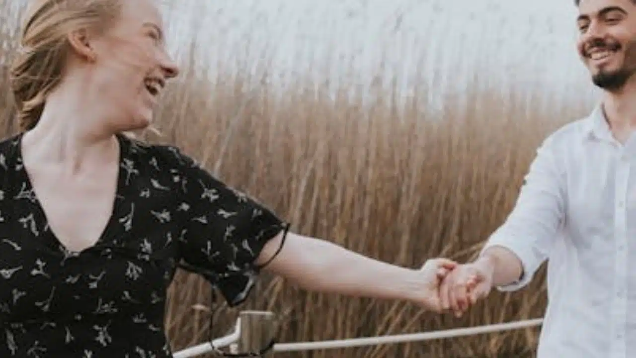 A couple laughing together in a park, conveying mutual respect.