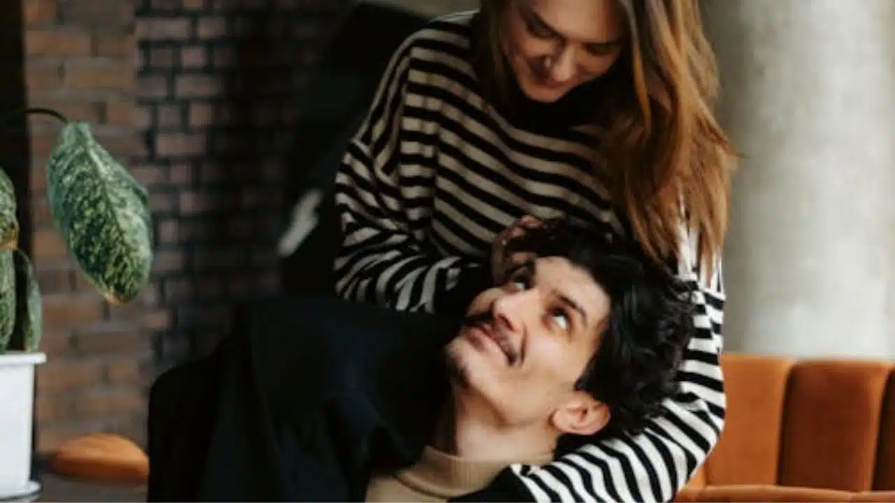 A couple having a heart to heart at home, seated comfortably and making eye contact.