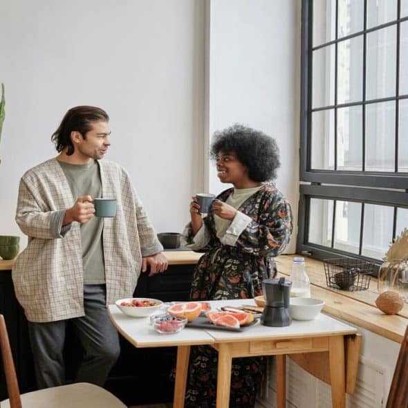 Happy couple having breakfast at home
