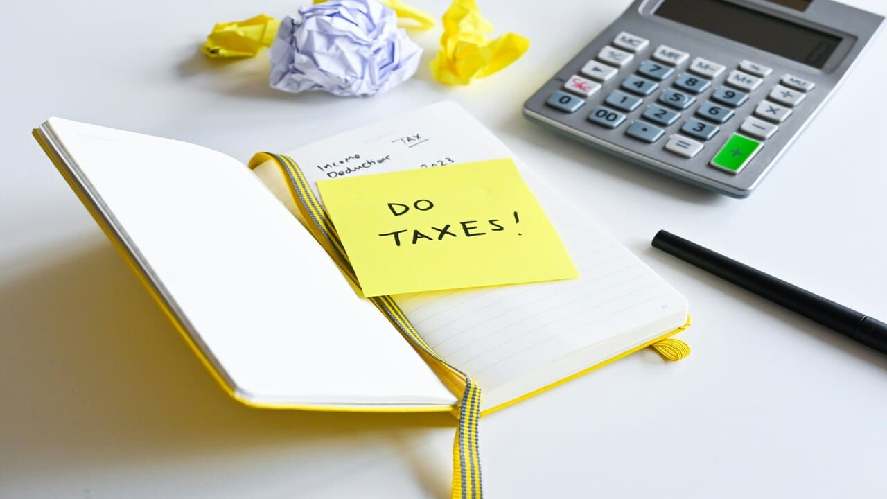 A notebook with a post-it saying “do taxes”.