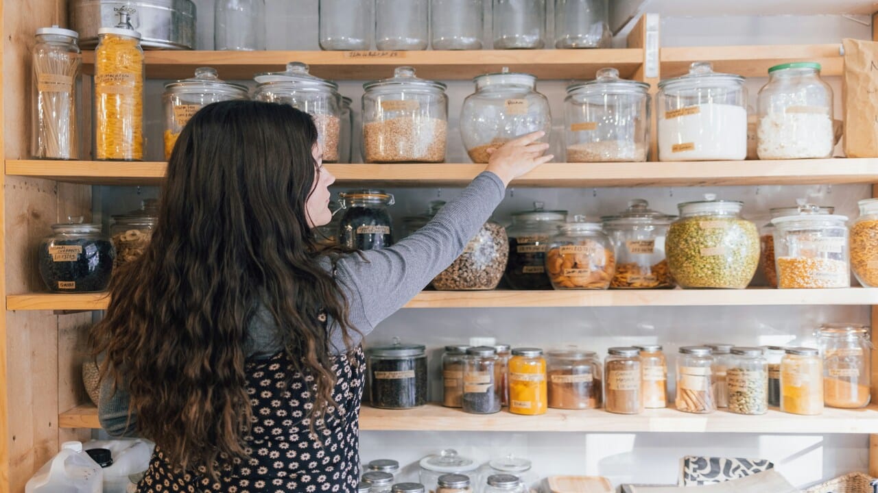 A woman getting a jar from her pantry.