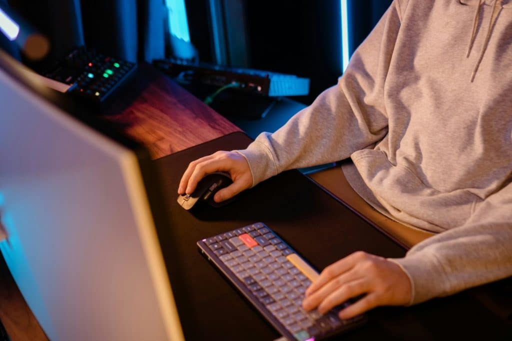 A person using a full desk mat for his keyboard and mouse.