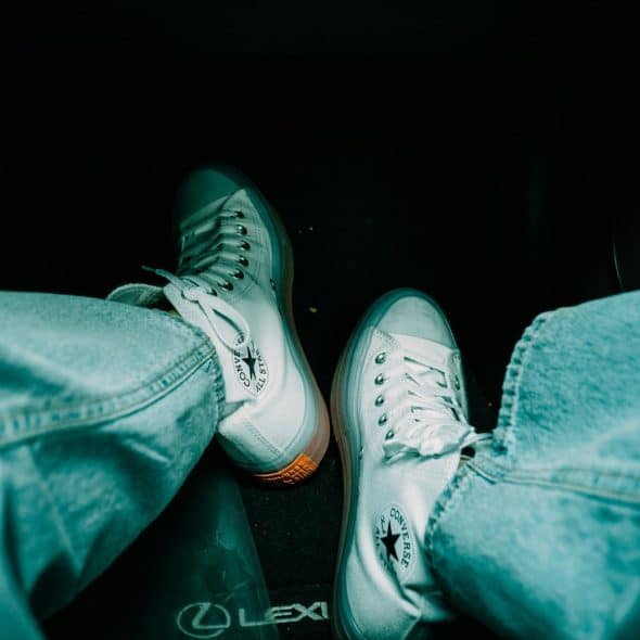 A person wearing a clean white shoes.