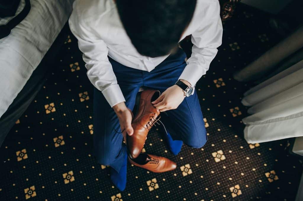 A picture of a man preparing to wear his brown shoes.