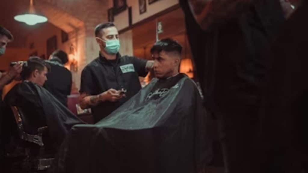 Men gathered in a barbershop space sitting and chatting informally.