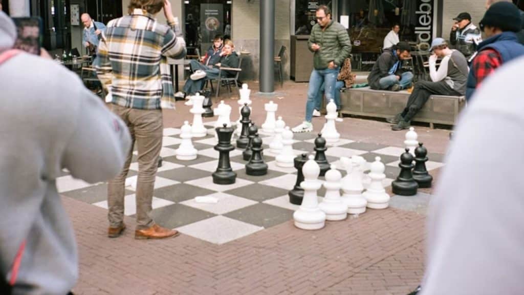 Group of men playing chess or board games with no phones in sight.