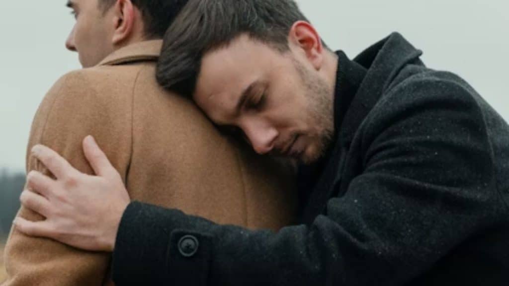 Close up of a man holding on a shoulder during a serious conversation.