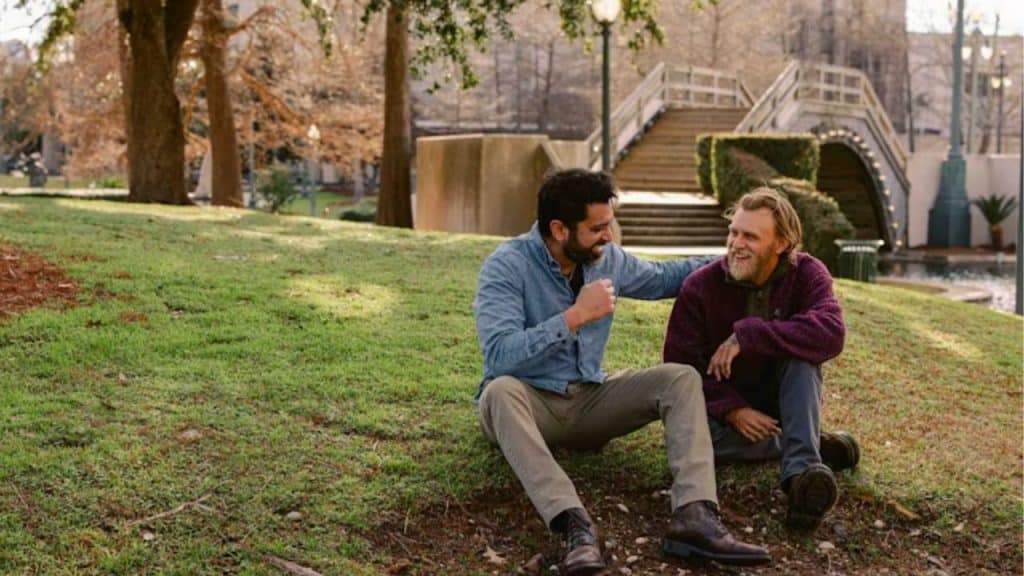 Two friends sitting on park steps sharing a quiet conversation.