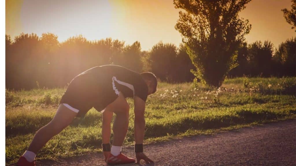 A man takes a reflective break from his workout, appearing mentally and physically exhausted.