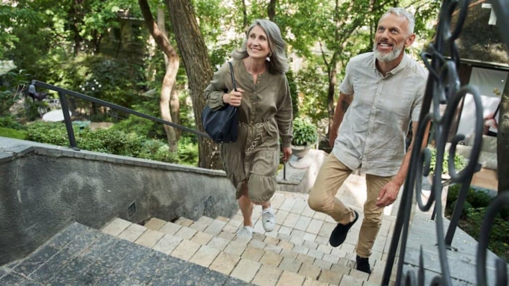 Interracial couple in their 50s enjoying a lighthearted walk outdoors.