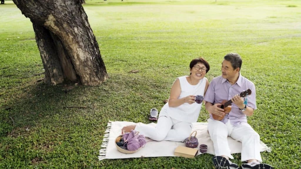 Middle-aged man and woman chatting with happy expressions at a park.