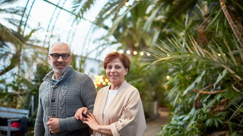 Older couple walking side by side at park, gradually connecting.
