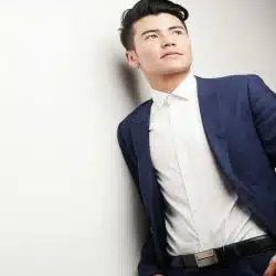 A man wearing a blue blazer and white dress shirt