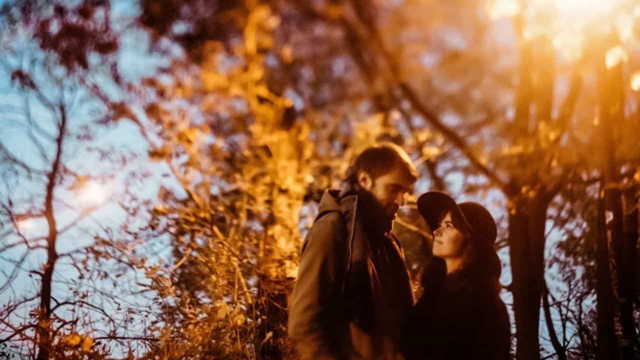 A joyful couple embracing in a scenic outdoor setting.