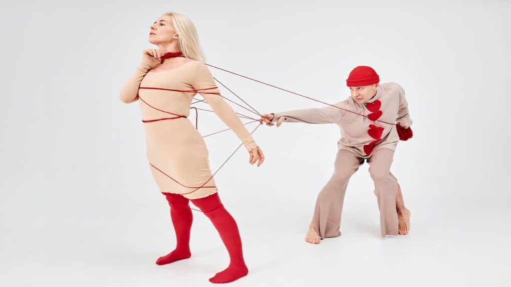 A photo of a man controlling a woman using a string