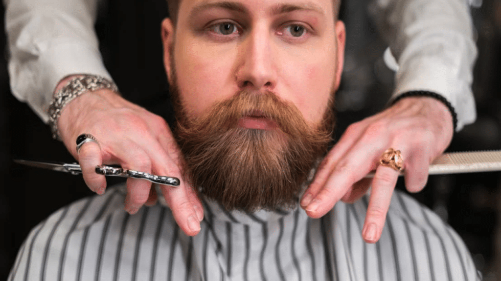 A man’s beard being professionally trimmed.