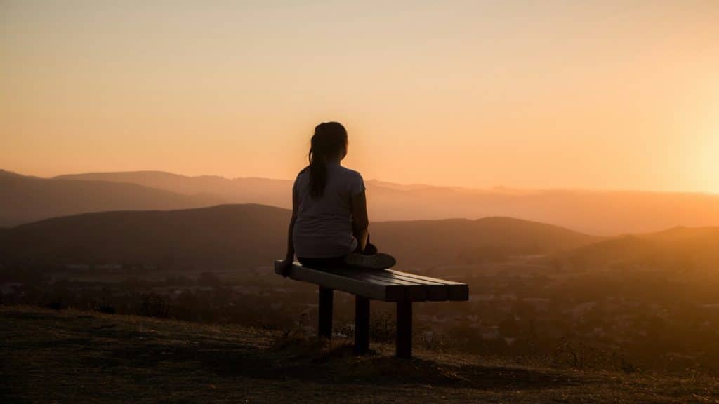 A woman by a bench overlooking a view