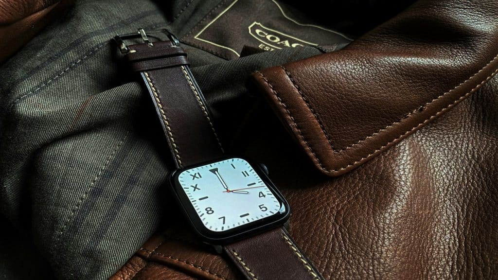 A photo of a smartwatch on top of a leather jacket.
