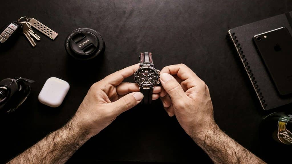A man adjusting the time on his wristwatch.