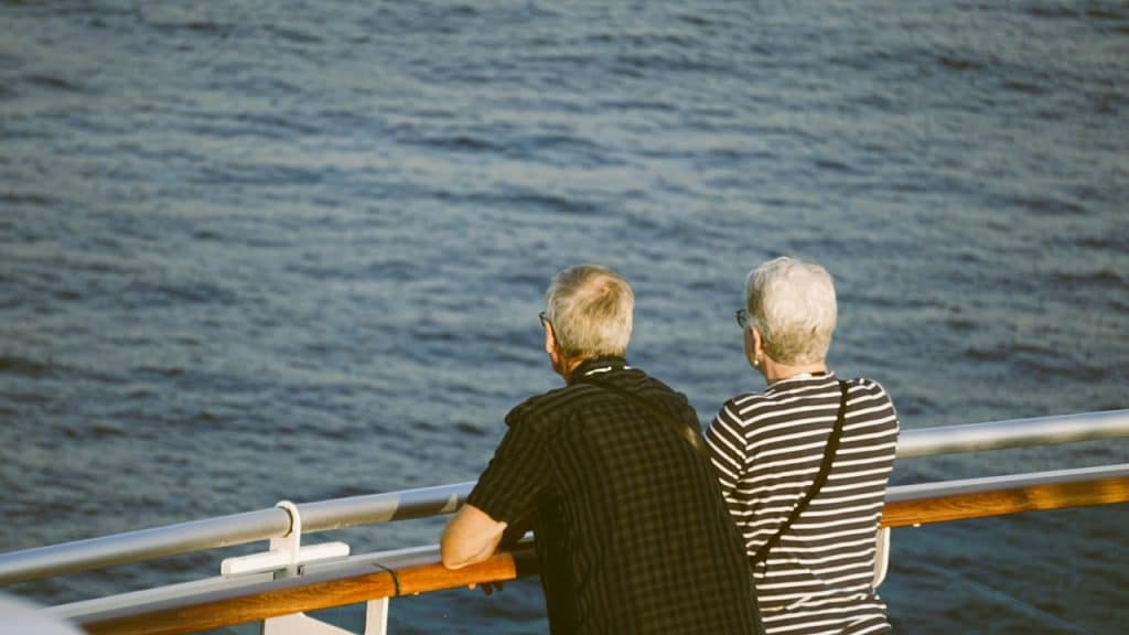 An old couple on a boat enjoying the ocean view.
