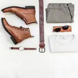 A pair of boots, shades, trousers, a belt, a watch, and a t-shirt.