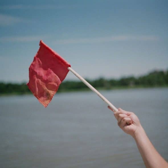 A hand holding a red flag