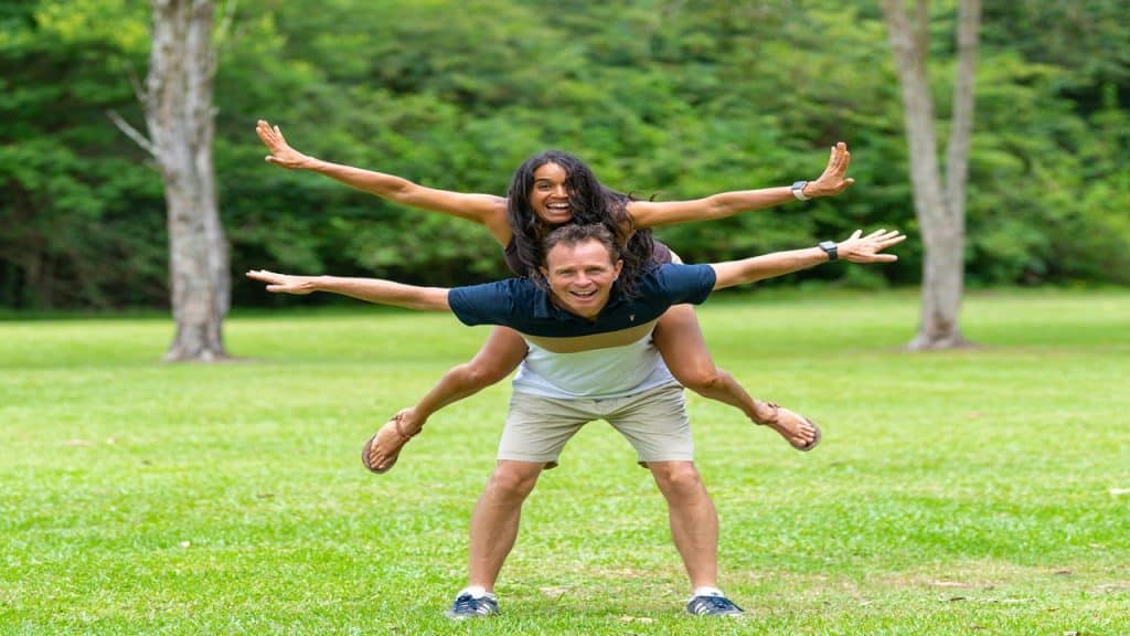 A happy couple posing for a picture outdoors.