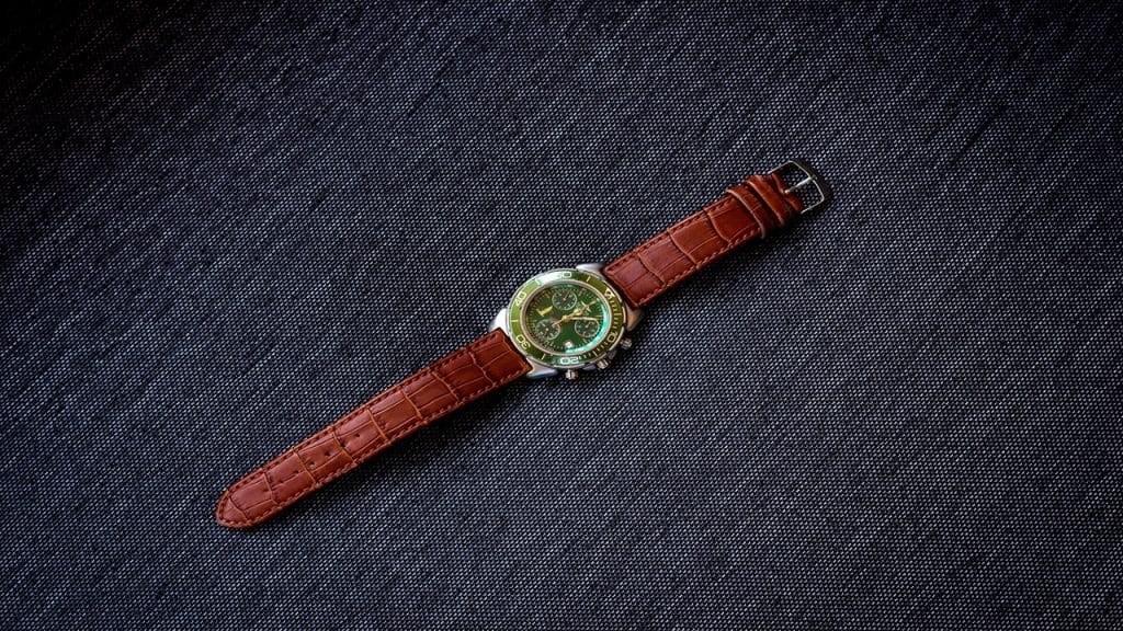 A photo of a dress watch resting on a fabric surface