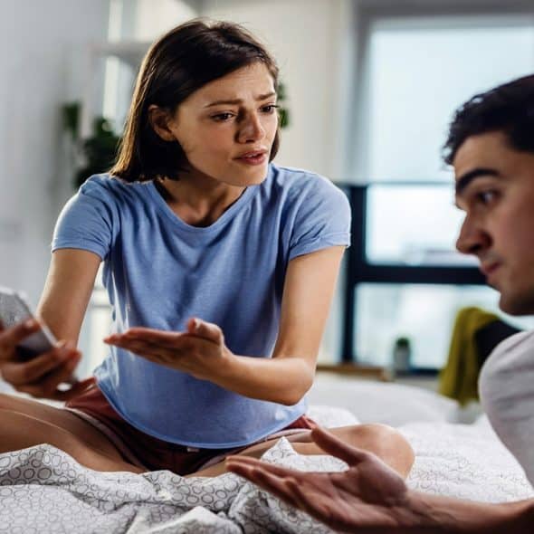 A couple arguing in the bedroom.