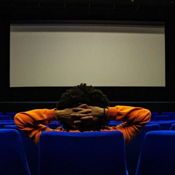A guy watching at cinema alone