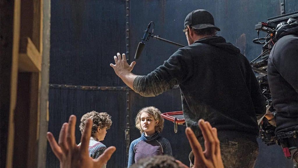 A director giving directions to two child actors.