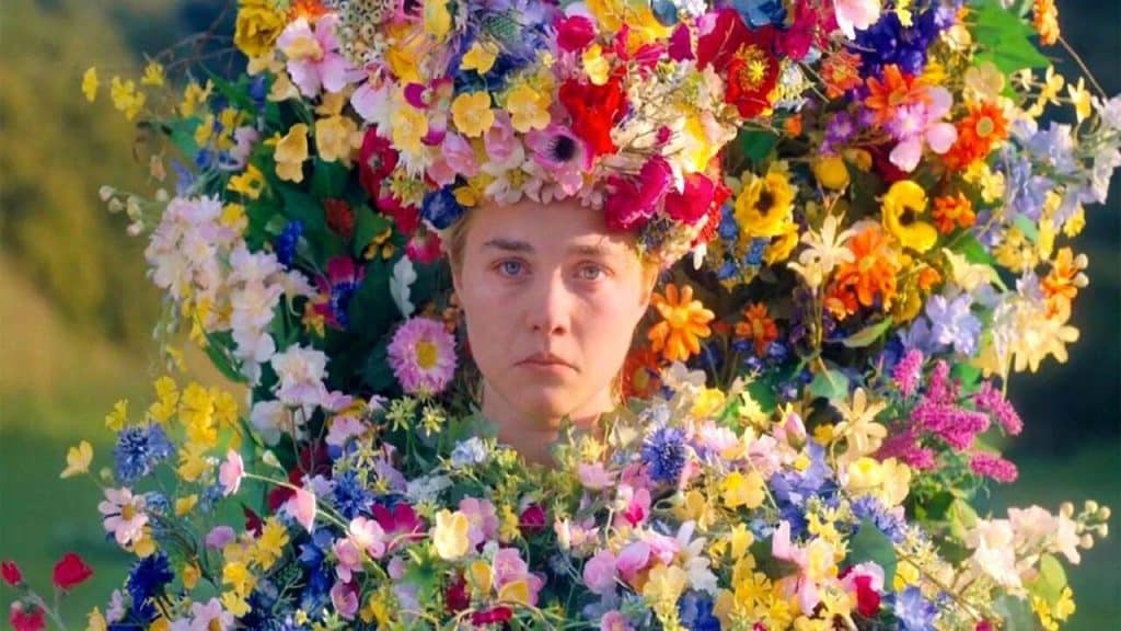 A woman who is covered in flowers and appears sad and depressed.
