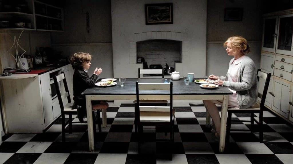 A mother and her son sitting at a dining table having dinner.