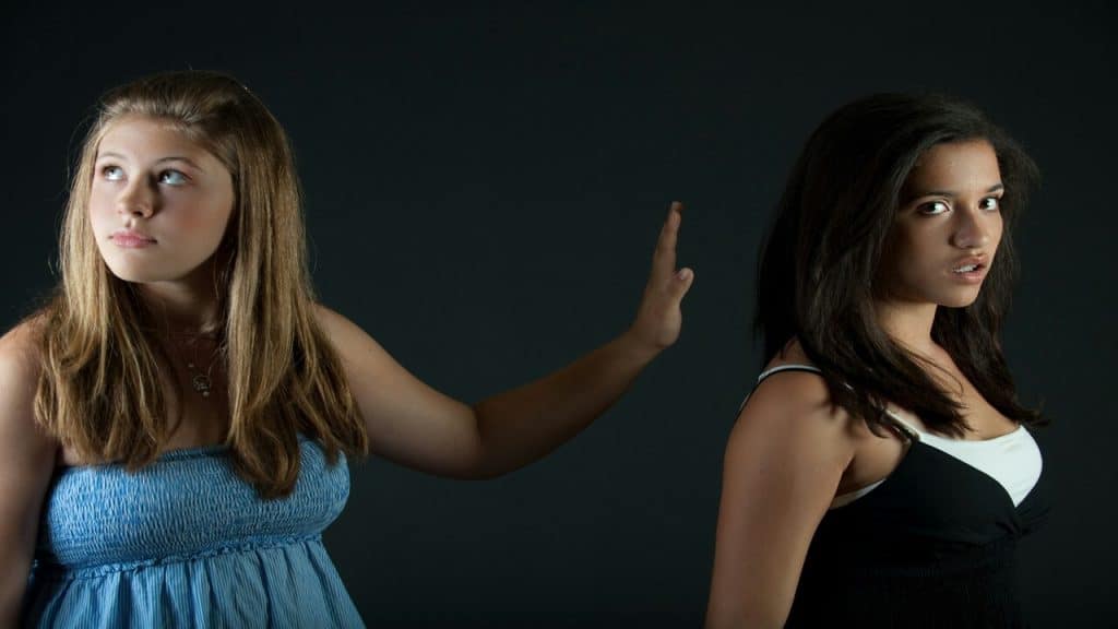 A girl does the “talk to the hand” sign to another girl