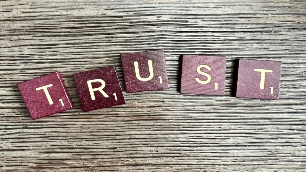 Scrabble letter forming the word “trust”