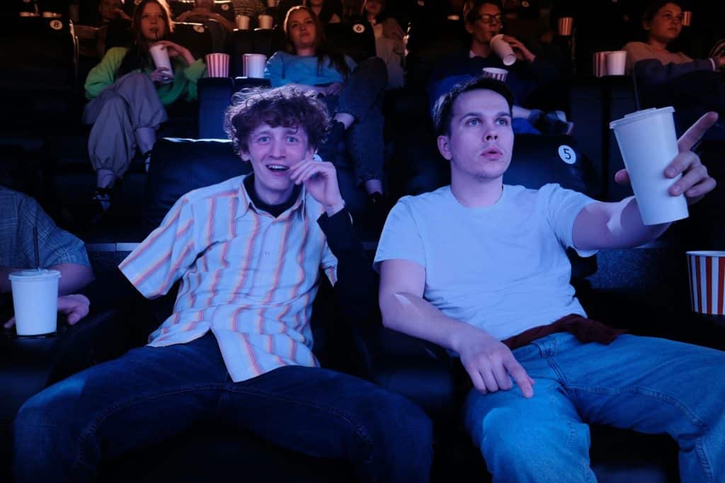 Two guys sitting in a cinema theater