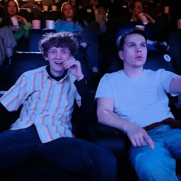 Two guys sitting in a cinema theater